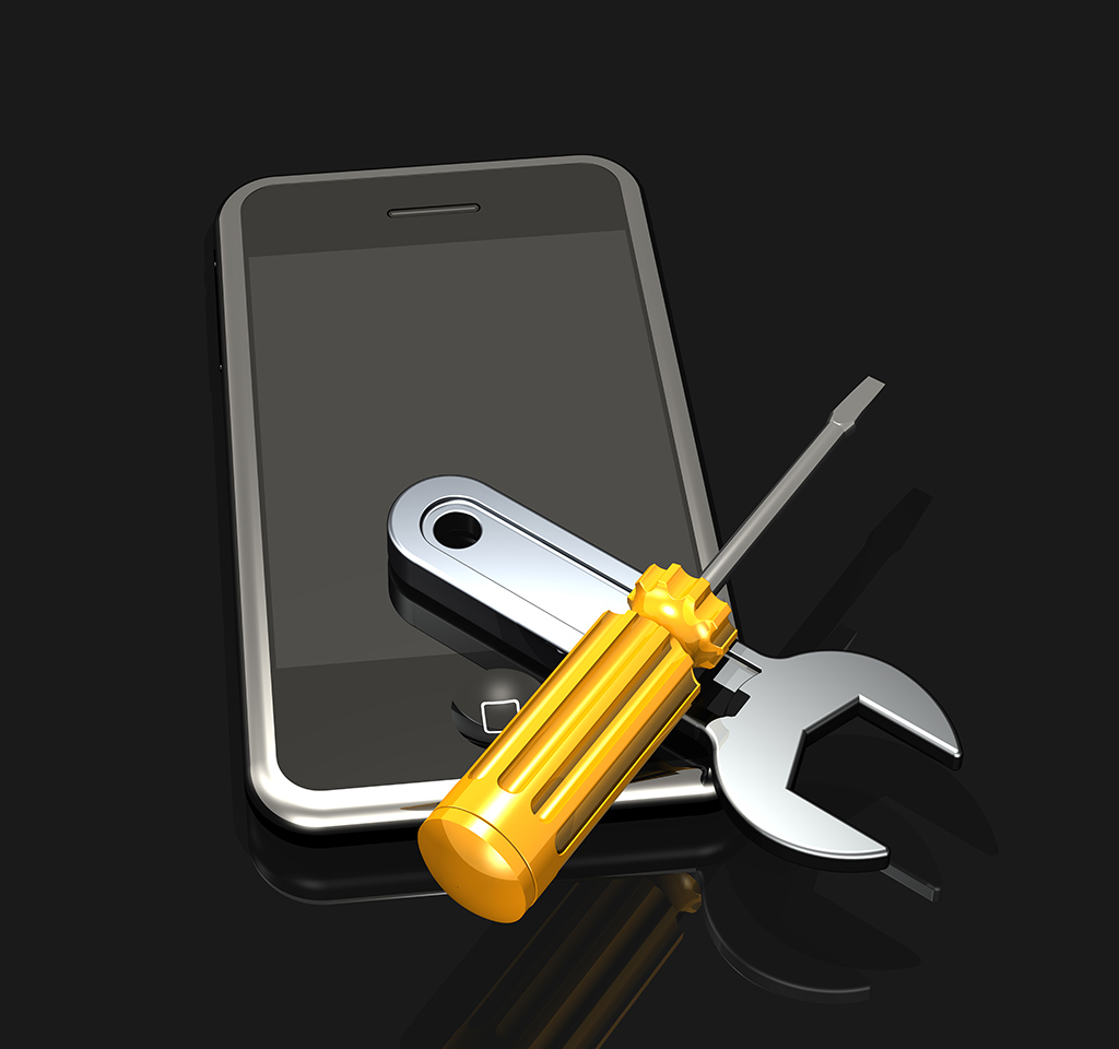 A wrench and screwdriver sitting on top of an iPhone 3Gs